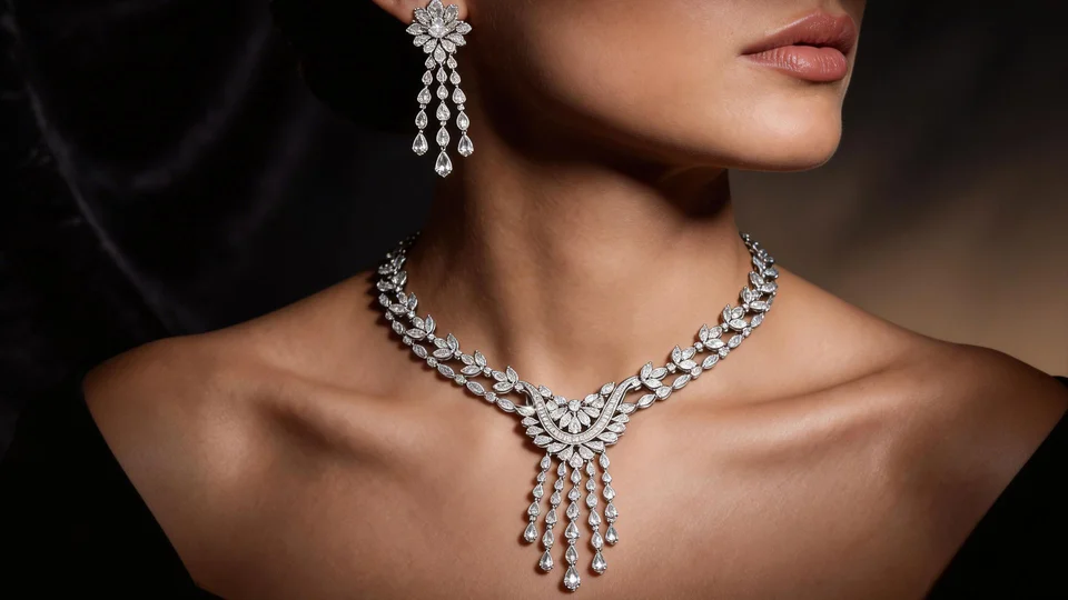 A detailed diamond necklace with drop pendant and matching earring